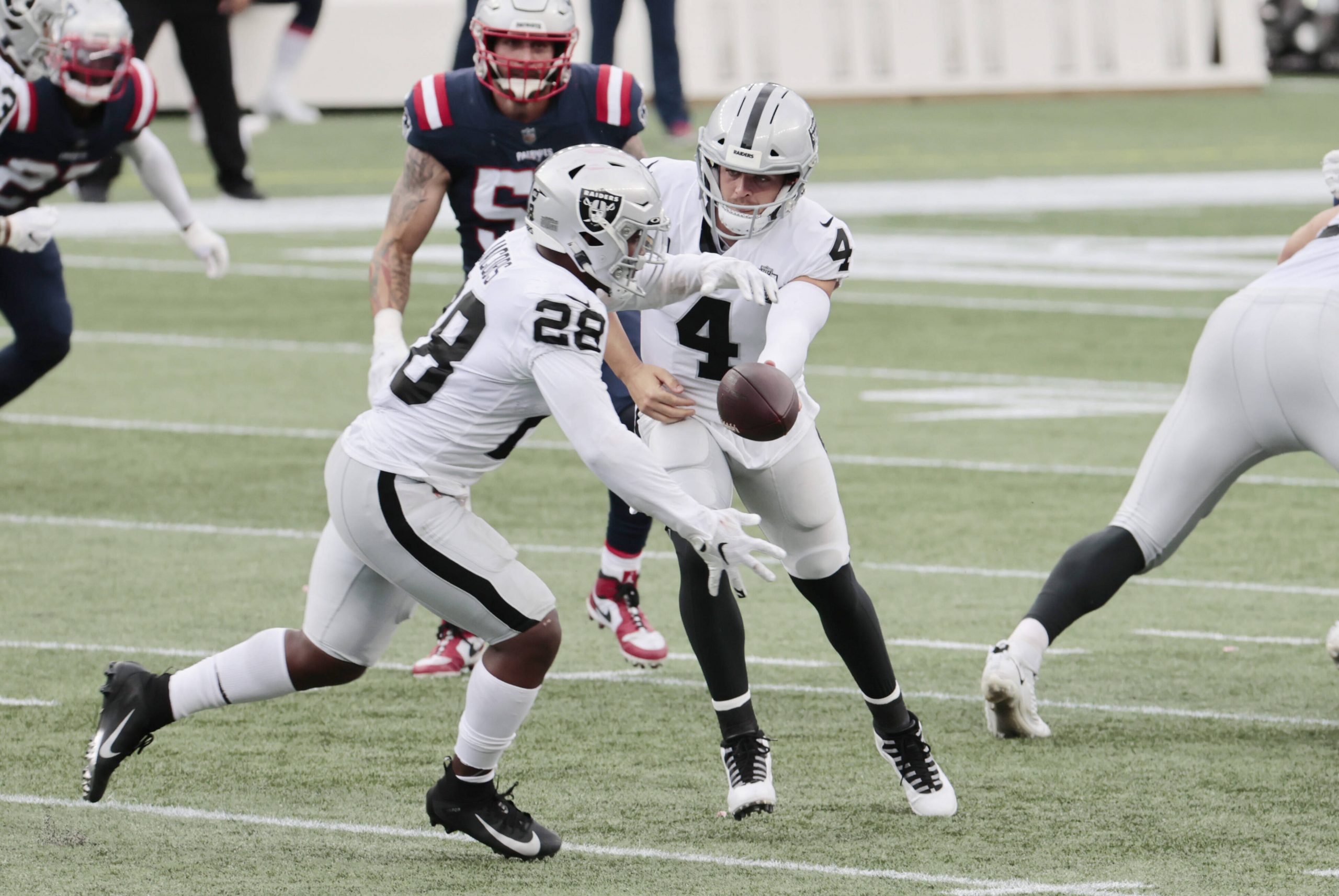 FOXBOROUGH, MA - SEPTEMBER 27: Las Vegas Raiders quarterback Derek Carr (4) hands off to Las Vegas Raiders running back