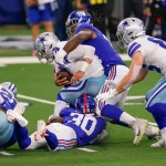 ARLINGTON, TX - OCTOBER 11: Dallas Cowboys Quarterback Dak Prescott (4) is sacked by New York Giants Linebacker Markus G