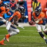 DENVER, CO - NOVEMBER 29: Denver Broncos quarterback Kendall Hinton (2) hands off to running back Melvin Gordon (25)