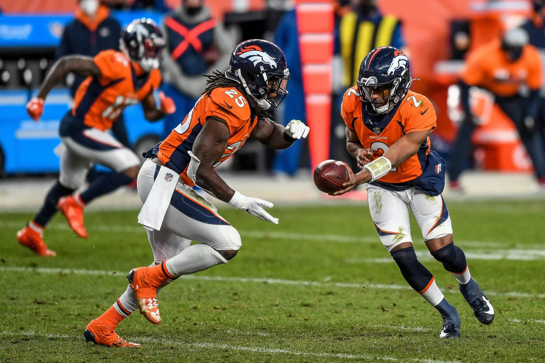 DENVER, CO - NOVEMBER 29: Denver Broncos quarterback Kendall Hinton (2) hands off to running back Melvin Gordon (25)