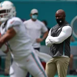 October 4, 2020, USA: Miami Dolphins coach Brian Flores watches quarterback Tua Tagovailoa warm up before their game aga