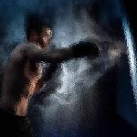 Ein verschwommenes, künstlerisches Bild eines Boxers mitten im Schlag. Der Boxer ist oben ohne und trägt Boxhandschuhe, während er auf eine Lichtquelle einschlägt. Der Hintergrund ist dunkel, mit rauchigen, dynamischen Effekten, die die Bewegung umgeben und eine dramatische und intensive Atmosphäre erzeugen. Diese Beschreibung wurde mit der FootballR KI automatisch generiert.