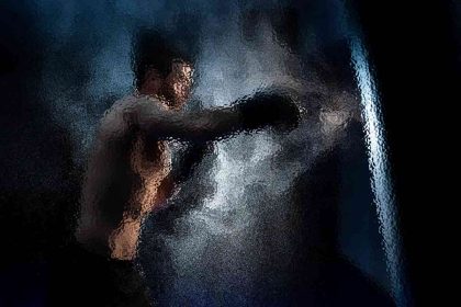 Ein verschwommenes, künstlerisches Bild eines Boxers mitten im Schlag. Der Boxer ist oben ohne und trägt Boxhandschuhe, während er auf eine Lichtquelle einschlägt. Der Hintergrund ist dunkel, mit rauchigen, dynamischen Effekten, die die Bewegung umgeben und eine dramatische und intensive Atmosphäre erzeugen. Diese Beschreibung wurde mit der FootballR KI automatisch generiert.