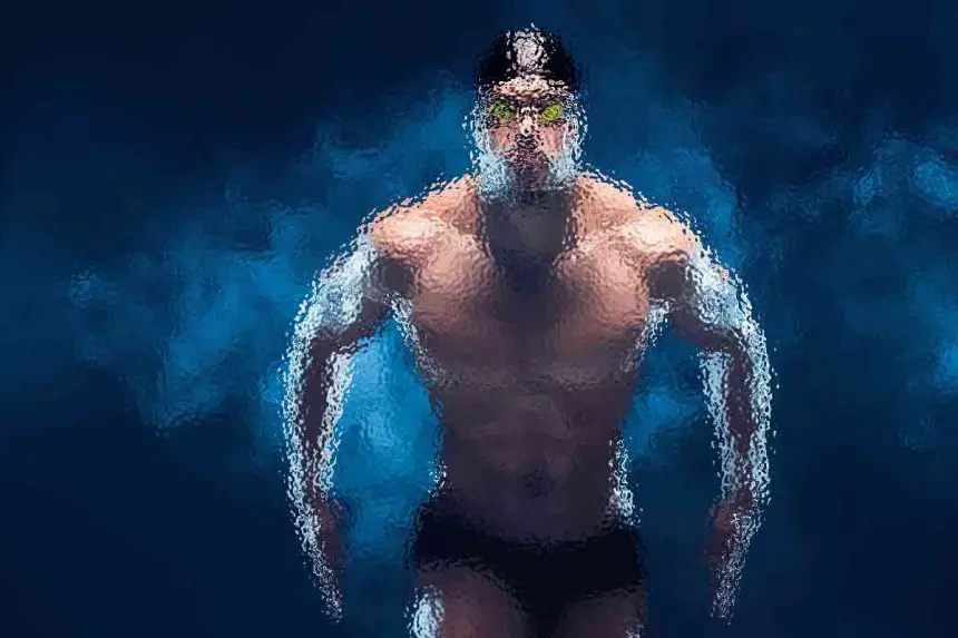 Ein Schwimmer mit Schwimmbrille, Badekappe und Badehose wird unter Wasser aufgenommen. Das Bild ist mit einem verschwommenen, künstlerischen Effekt stilisiert, der den muskulösen Körperbau und die dynamische Bewegung vor einem tiefblauen Hintergrund betont. Blasen und Lichtreflexionen verstärken die Unterwasseratmosphäre. Diese Beschreibung wurde mit der FootballR KI automatisch generiert.