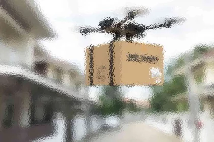 Eine Drohne mit einem Kartonpaket fliegt über eine verschwommene Vorstadtstraße. Das Paket ist braun und die Drohne hat mehrere Propeller. Im Hintergrund sind Häuser und Grünflächen mit einem Unschärfeeffekt zu sehen, der auf Bewegung oder einen Kamerafilter hindeutet. Diese Beschreibung wurde mit der FootballR KI automatisch generiert.
