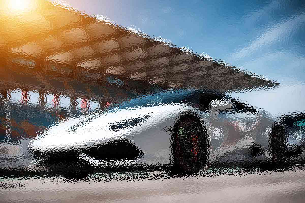 Künstlerische Darstellung eines eleganten weißen Sportwagens auf einer Rennstrecke mit verschwommenen Bewegungen. Der Hintergrund zeigt eine große Tribüne unter blauem Himmel, wobei das Sonnenlicht einen warmen Schein erzeugt. Das Bild hat einen strukturierten, impressionistischen Effekt, der das Gefühl von Geschwindigkeit und Energie verstärkt. Diese Beschreibung wurde mit der FootballR KI automatisch generiert.