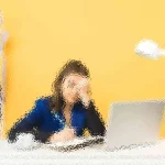 Eine Person sitzt mit einem Laptop an einem Schreibtisch und wirkt müde, die Hand liegt auf der Stirn. Sie befindet sich in einem Raum mit einer leuchtend gelben Wand. Auf dem Schreibtisch steht eine weiße Lampe, im Hintergrund ist ein Regal mit bunten Ordnern und einer kleinen Topfpflanze zu sehen. Diese Beschreibung wurde mit der FootballR KI automatisch generiert.