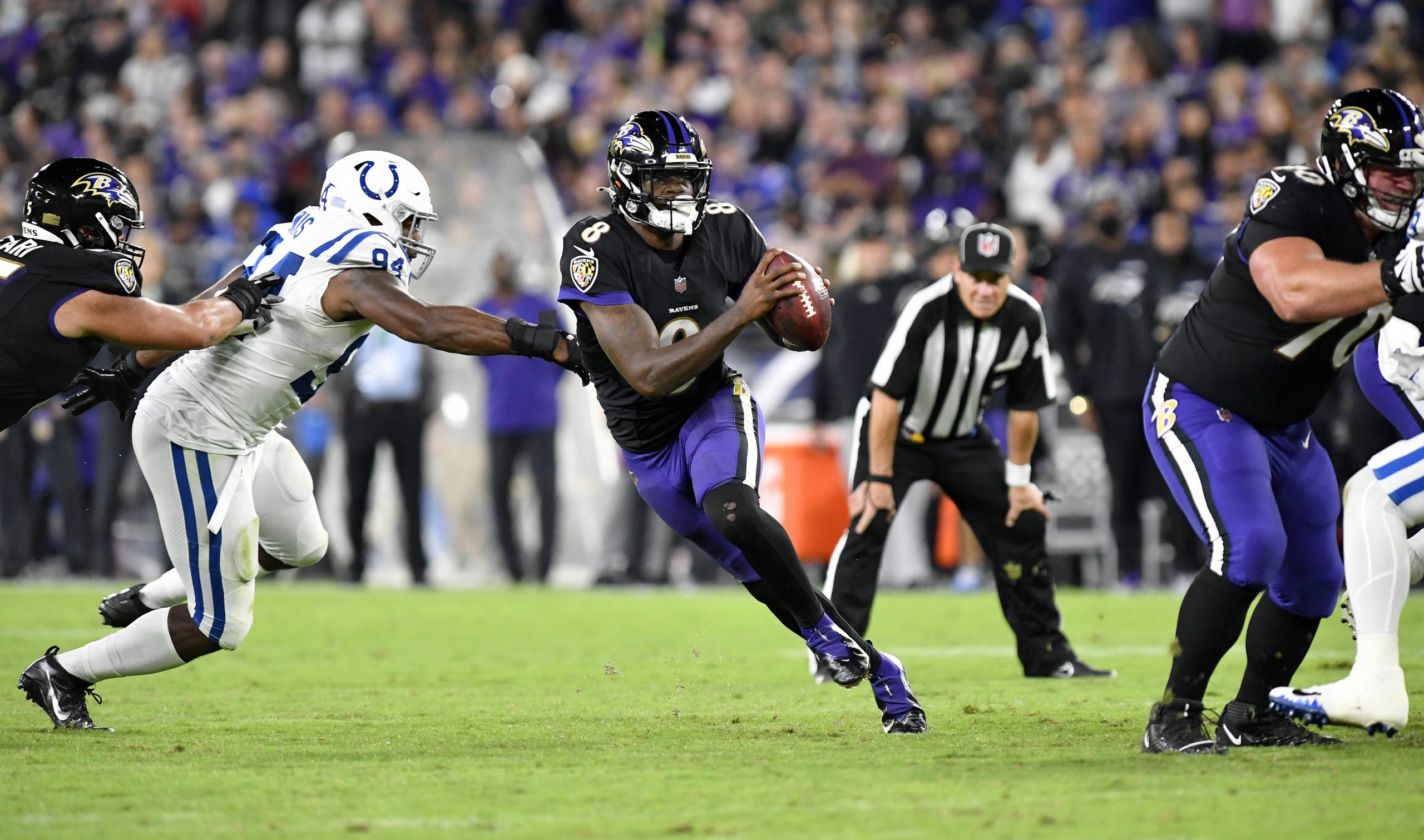 BALTIMORE, MD - OCTOBER 11: Baltimore Ravens quarterback Lamar Jackson (8) scrambles away form pressure by Colts defensi