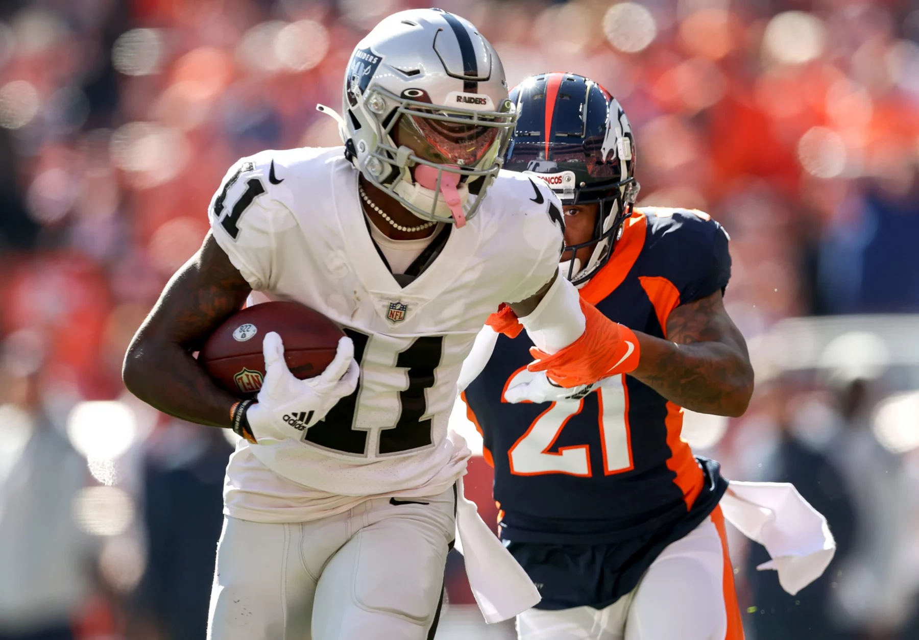 DENVER, CO - OCTOBER 17: Las Vegas Raiders wide receiver Henry Ruggs III (11) fights off Denver Broncos cornerback Rona