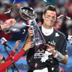 Tampa Bay Buccaneers quarterback Tom Brady stands with one of his children as he is presented the Vince Lombardi Trophy