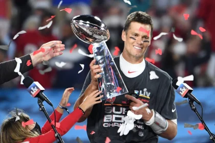 Tampa Bay Buccaneers quarterback Tom Brady stands with one of his children as he is presented the Vince Lombardi Trophy
