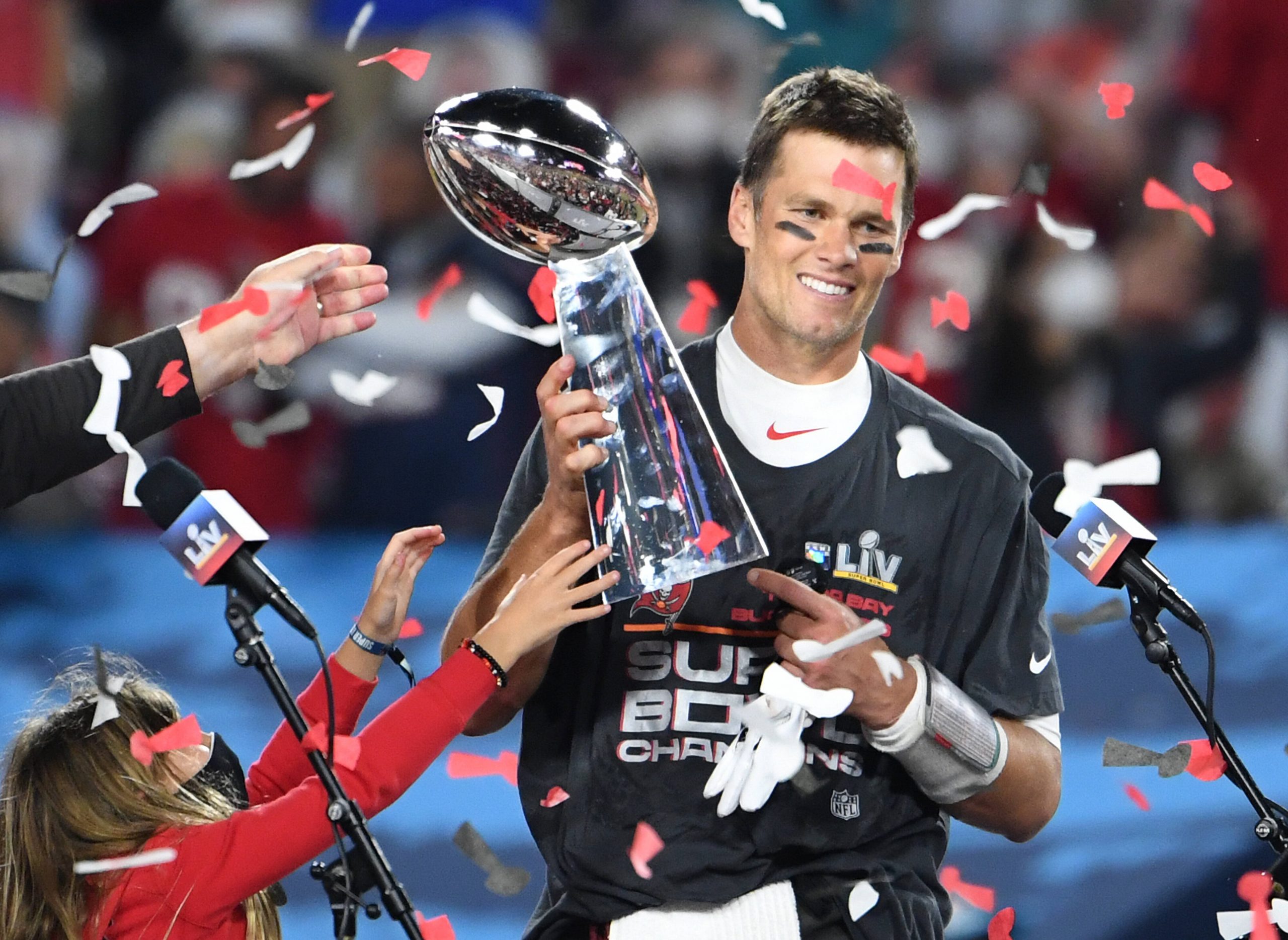 Tampa Bay Buccaneers quarterback Tom Brady stands with one of his children as he is presented the Vince Lombardi Trophy
