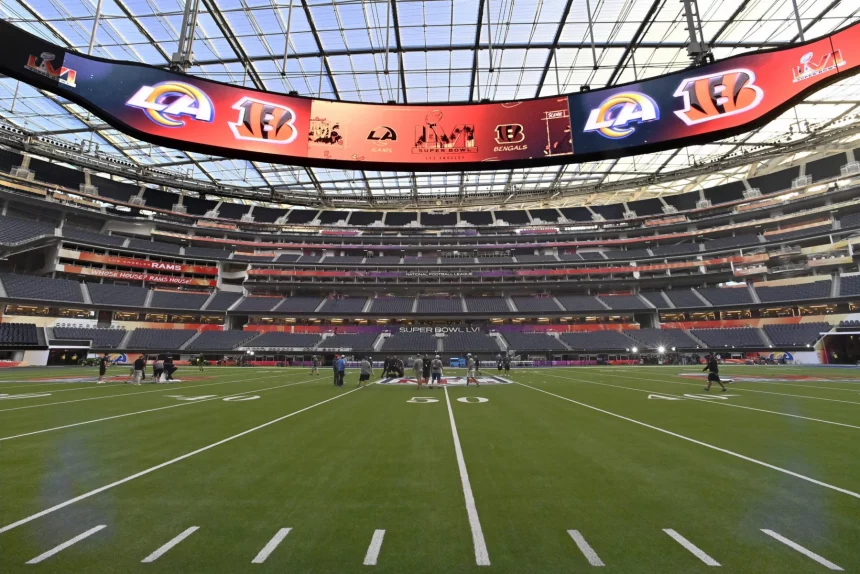 Workers make last minute preparations on the SoFi Stadium field for Sunday s LVI Super Bowl in Inglewood California on S