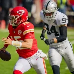 Kansas City Chiefs quarterback Patrick Mahomes (15) runs away from Las Vegas Raiders defensive end Carl Nassib (94) in t