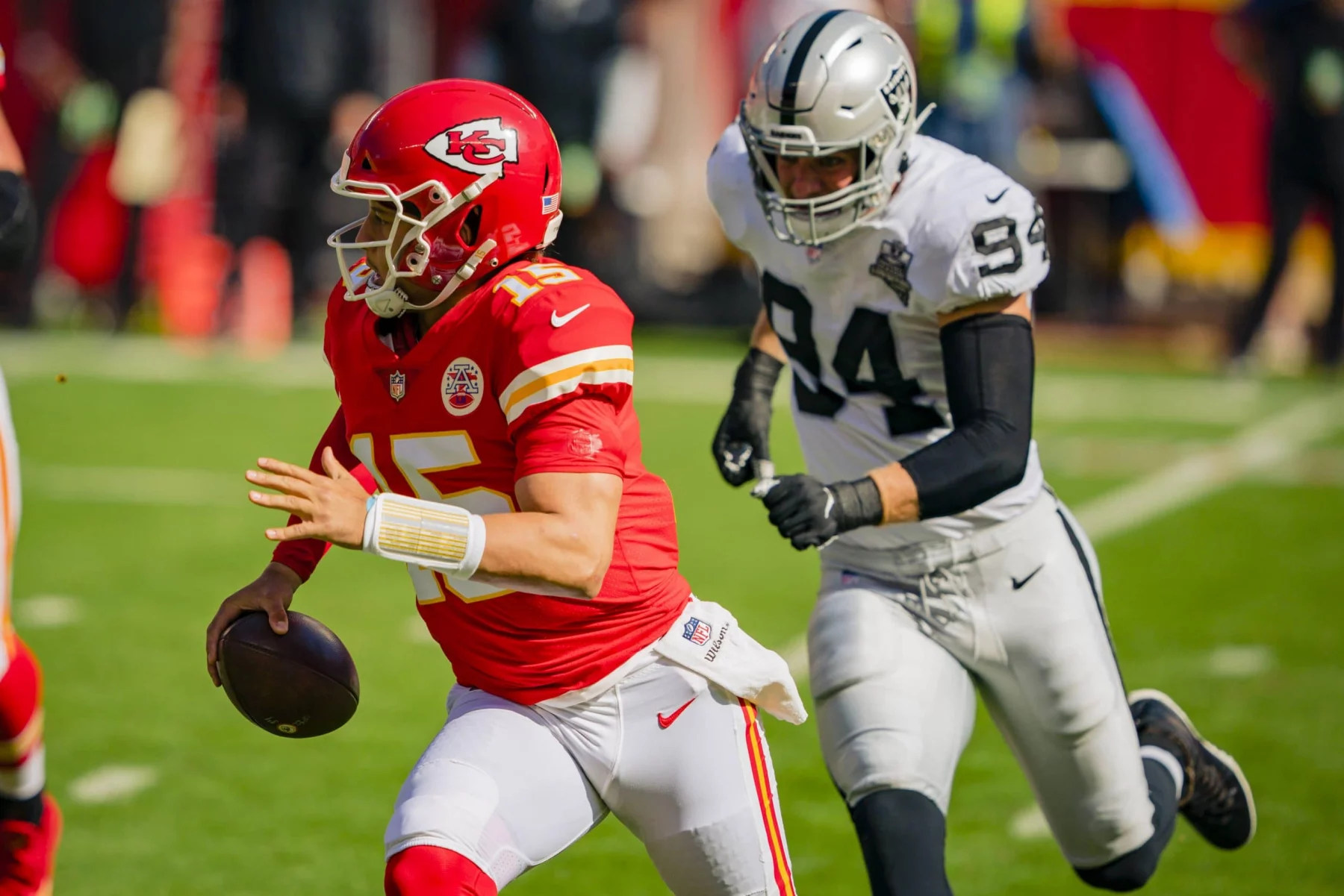 Kansas City Chiefs quarterback Patrick Mahomes (15) runs away from Las Vegas Raiders defensive end Carl Nassib (94) in t