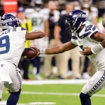 FootballR - NFL - Die Seattle Seahawks und die New Orleans Saints spielen Football. Geno Smith 7 übergibt den ball an running back Kenneth Walker III 9