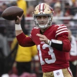 FootballR - NFL Woche 13 - Ein Footballspieler der San Francisco 49ers, Brock Purdy, wirft einen Ball.