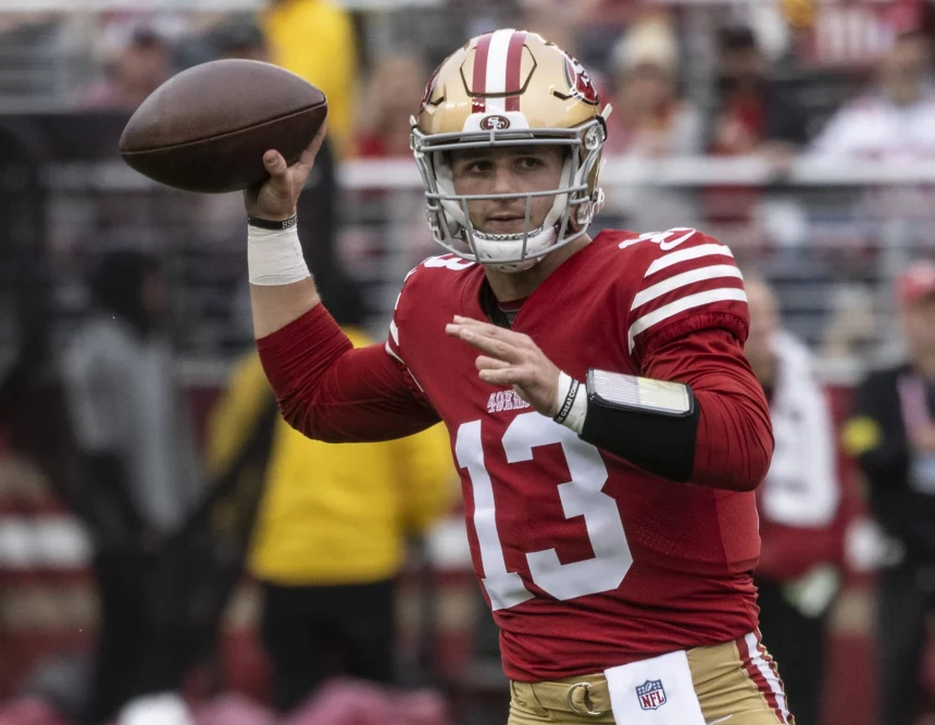 FootballR - NFL Woche 13 - Ein Footballspieler der San Francisco 49ers, Brock Purdy, wirft einen Ball.