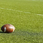 American Football (Ball) liegt auf dem Spielfeld