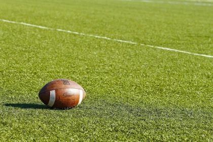 American Football (Ball) liegt auf dem Spielfeld