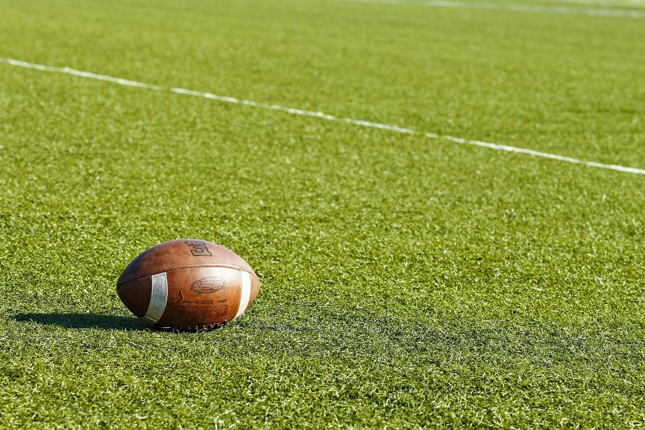 American Football (Ball) liegt auf dem Spielfeld