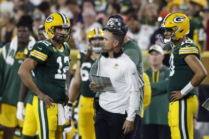 Quarterback Aaron Rodgers spricht mit Packers Headcoach Matt LaFleur, Jordan Love hört zu
