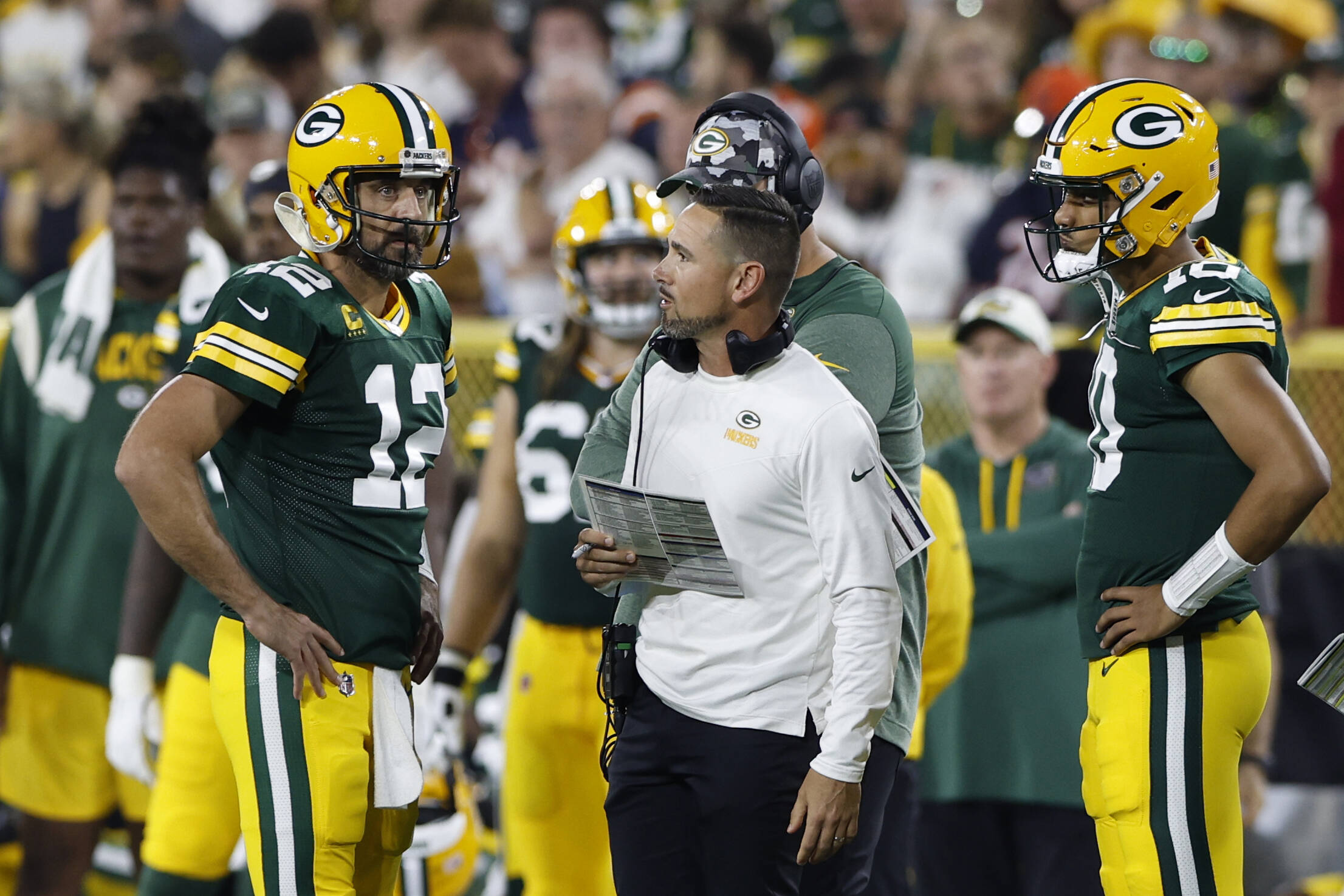 Quarterback Aaron Rodgers spricht mit Packers Headcoach Matt LaFleur, Jordan Love hört zu