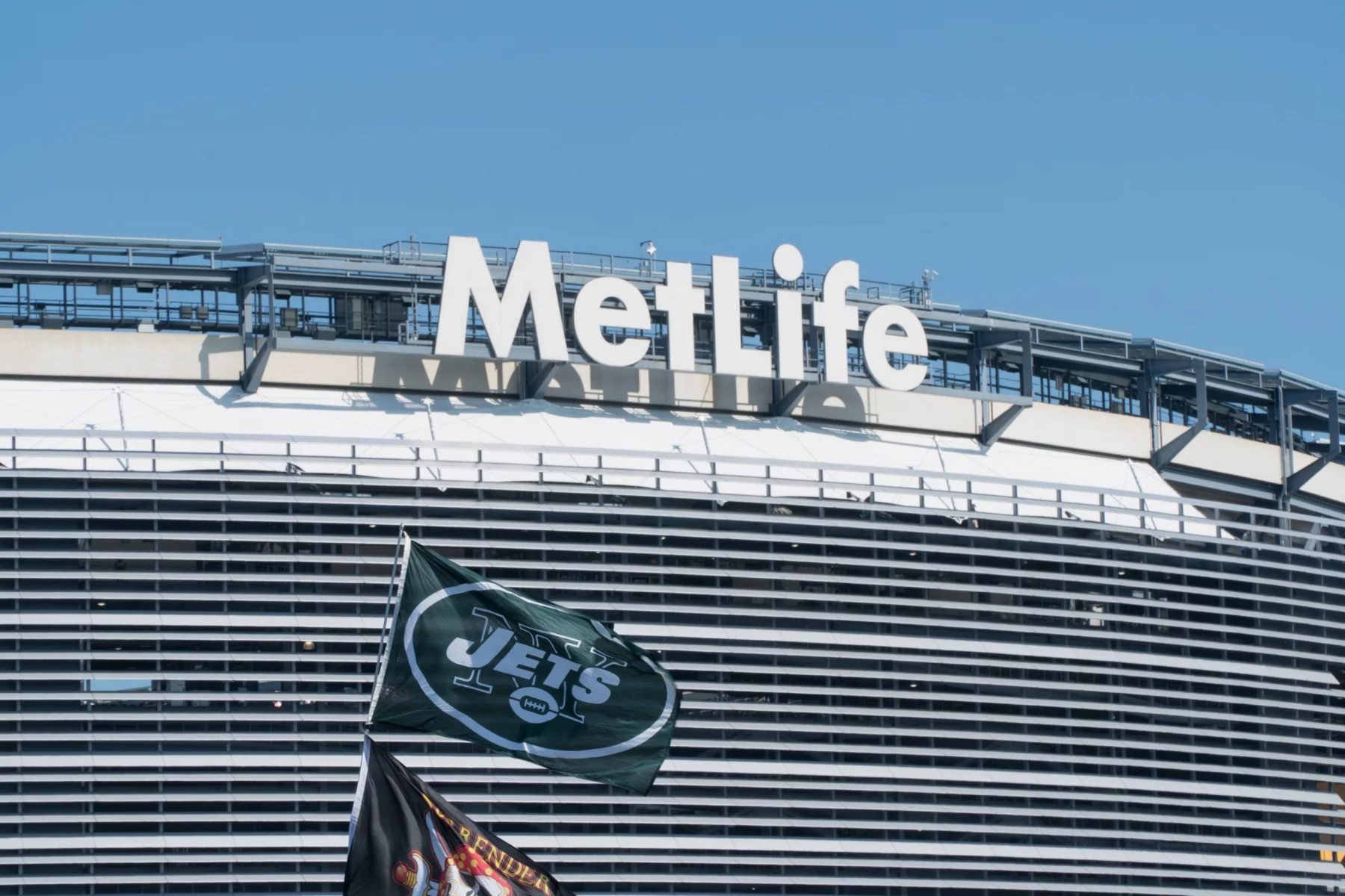 East Rutherford, New Jersey - Circa 2017: New York Jets football team flag waves in wind during parking lot tailgate outside Metlife Stadium before season game