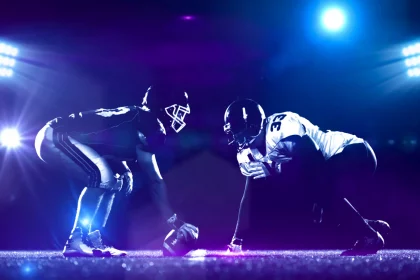 american football players are ready to start on field at night