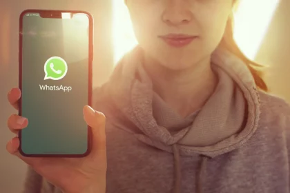 KYIV, UKRAINE-JANUARY, 2020: Whatsapp on Mobile Phone Screen. Young Girl Showing Smartphone Screen with Whatsapp on it while Looking at the Camera. Focus on Smartphone.