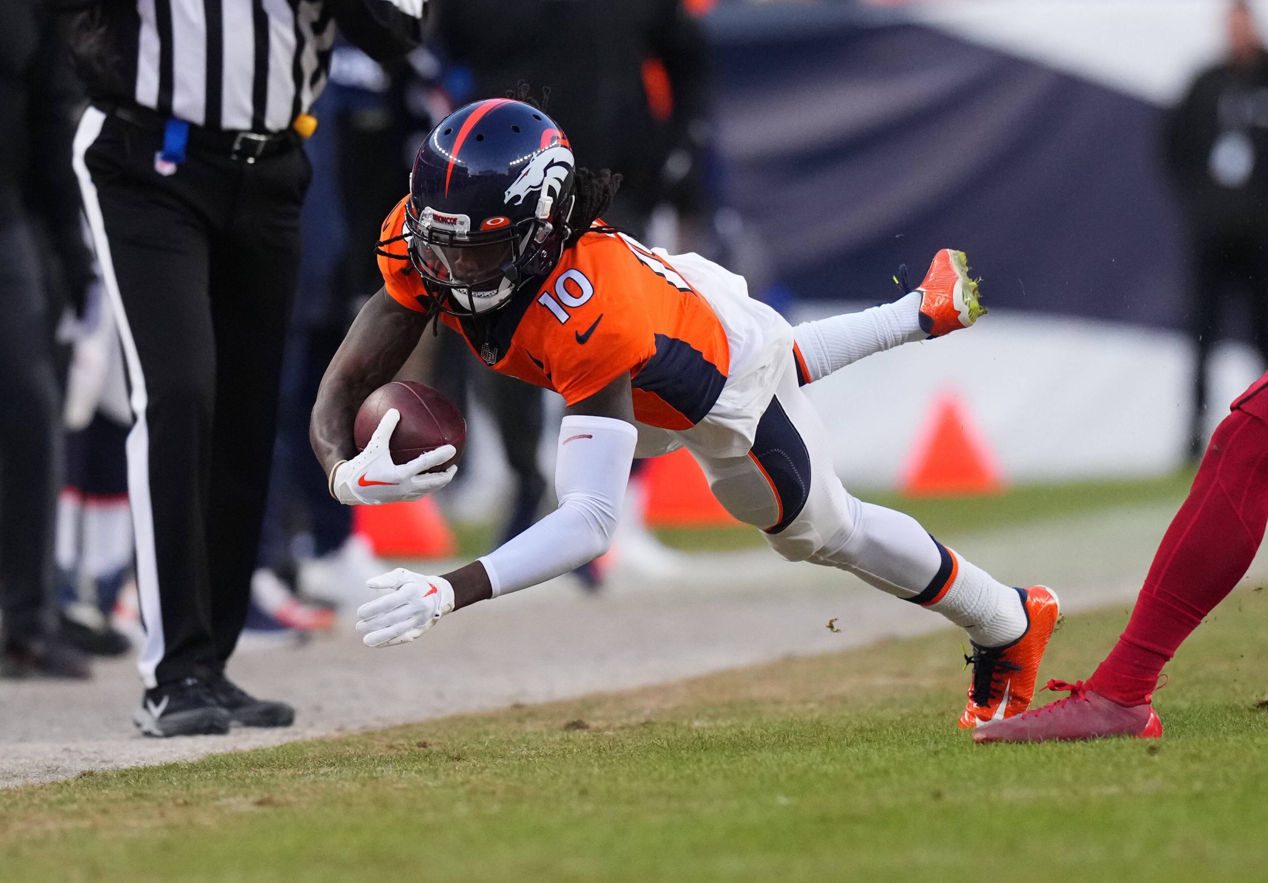 FootballR - NFL - Der Wide Receiver der Denver Broncos, Jerry Jeudy, hechtet mit dem Ball.