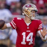 FootballR - NFL - Ein Footballspieler der San Francisco 49ers, Sam Darnold, wirft den Ball.
