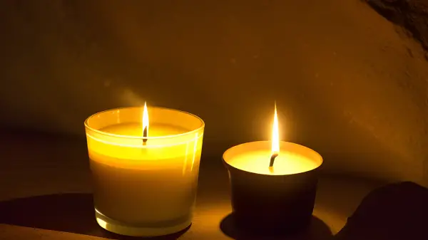 FootballR - NFL - Zwei Kerzen brennen in einem dunklen Raum.