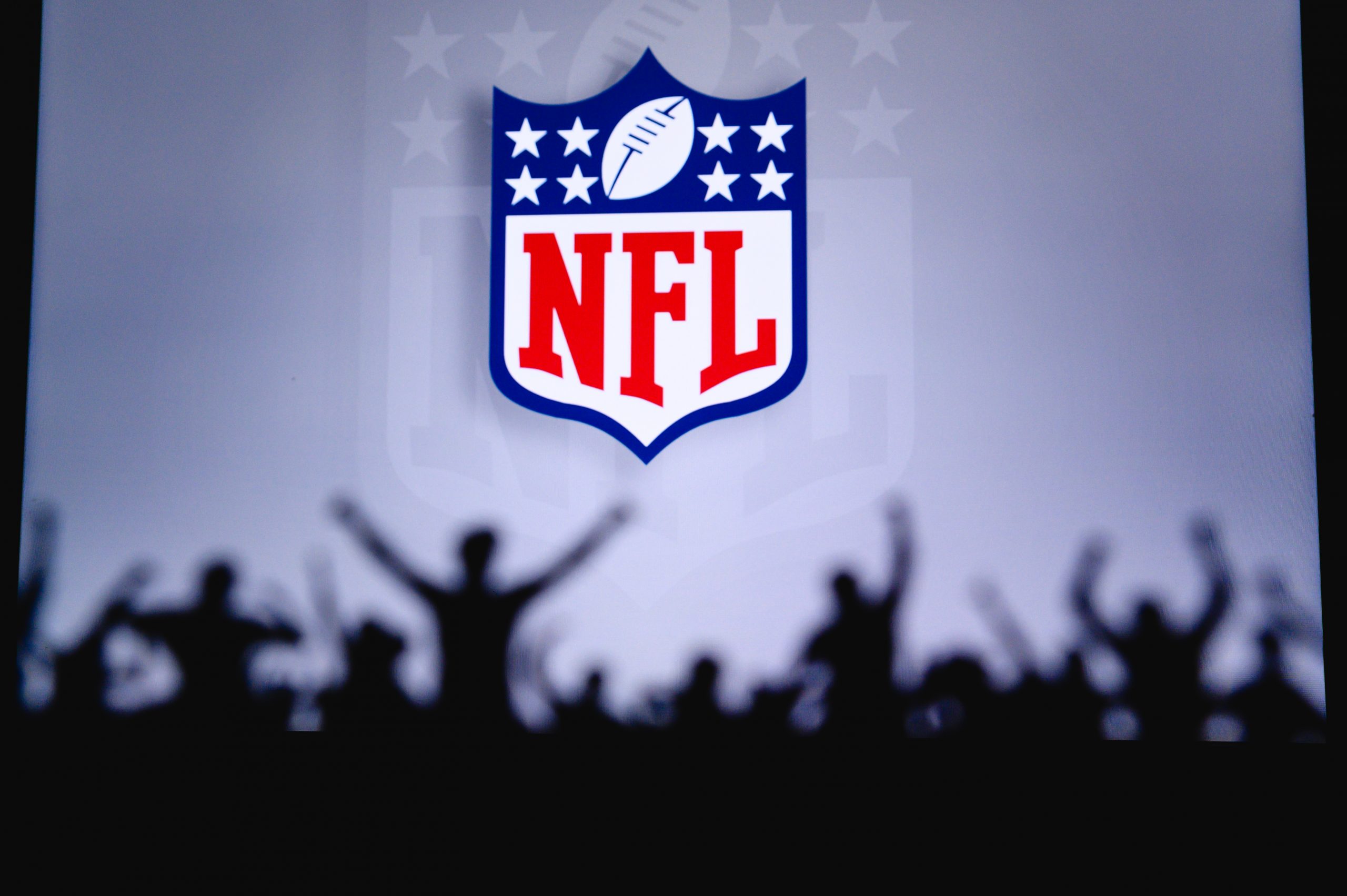 FootballR - NFL - Das NFL-Logo erscheint im dritten Viertel als Silhouette vor einer Menschenmenge und verdeutlicht die Bedeutung von Notfall-Quarterbacks. NFL Standings, NFL Tabelle