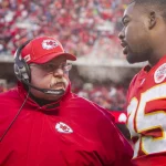 FootballR - NFL - Zwei NFL-Spieler, Chris Jones und ein Coach, unterhalten sich auf dem Spielfeld.