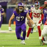 FootballR - NFL - Footballspieler der Minnesota Vikings, T.J. Hockenson läuft mit dem Ball.
