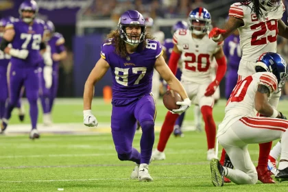 FootballR - NFL - Footballspieler der Minnesota Vikings, T.J. Hockenson läuft mit dem Ball.