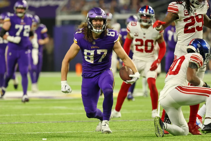 FootballR - NFL - Footballspieler der Minnesota Vikings, T.J. Hockenson läuft mit dem Ball.