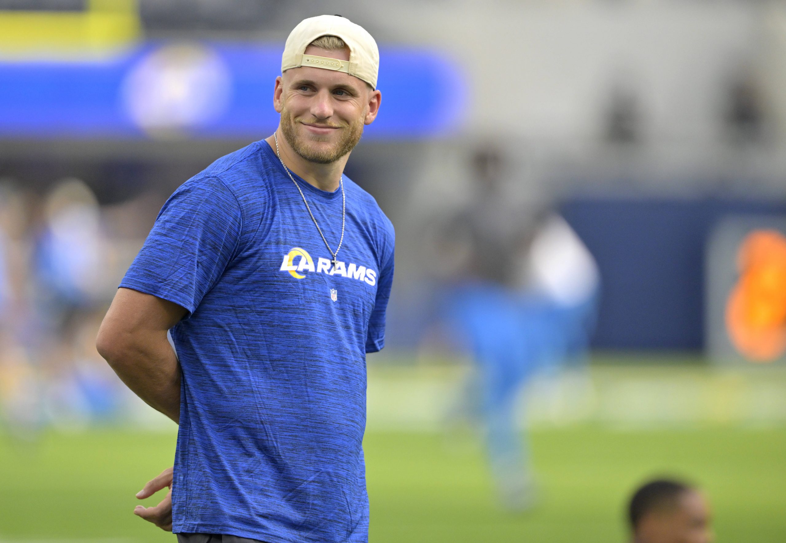 FootballR - NFL - Ein Mann in einem blauen Hemd (Cooper Kupp) steht auf einem Fitnessfeld.