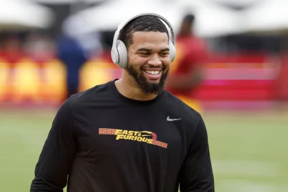 FootballR - NFL - Ein USC-Quarterback namens Caleb Williams, der Kopfhörer trägt und auf dem Spielfeld lächelt.