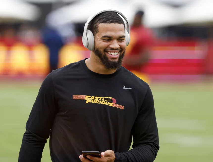 FootballR - NFL - Ein USC-Quarterback namens Caleb Williams, der Kopfhörer trägt und auf dem Spielfeld lächelt.