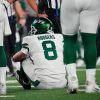 FootballR - NFL - Ein Footballspieler, Aaron Rodgers, sitzt verletzt am Boden draußen.
