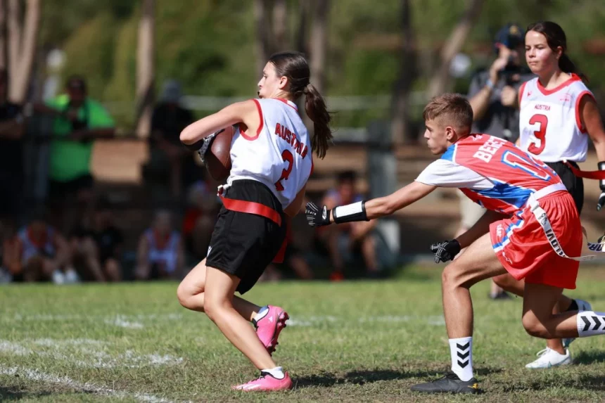 FootballR - NFL - Eine Gruppe Mädchen spielt Flag-Football auf einem Feld.