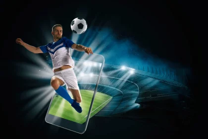 Soccer player, cellphone and ball on a stadium