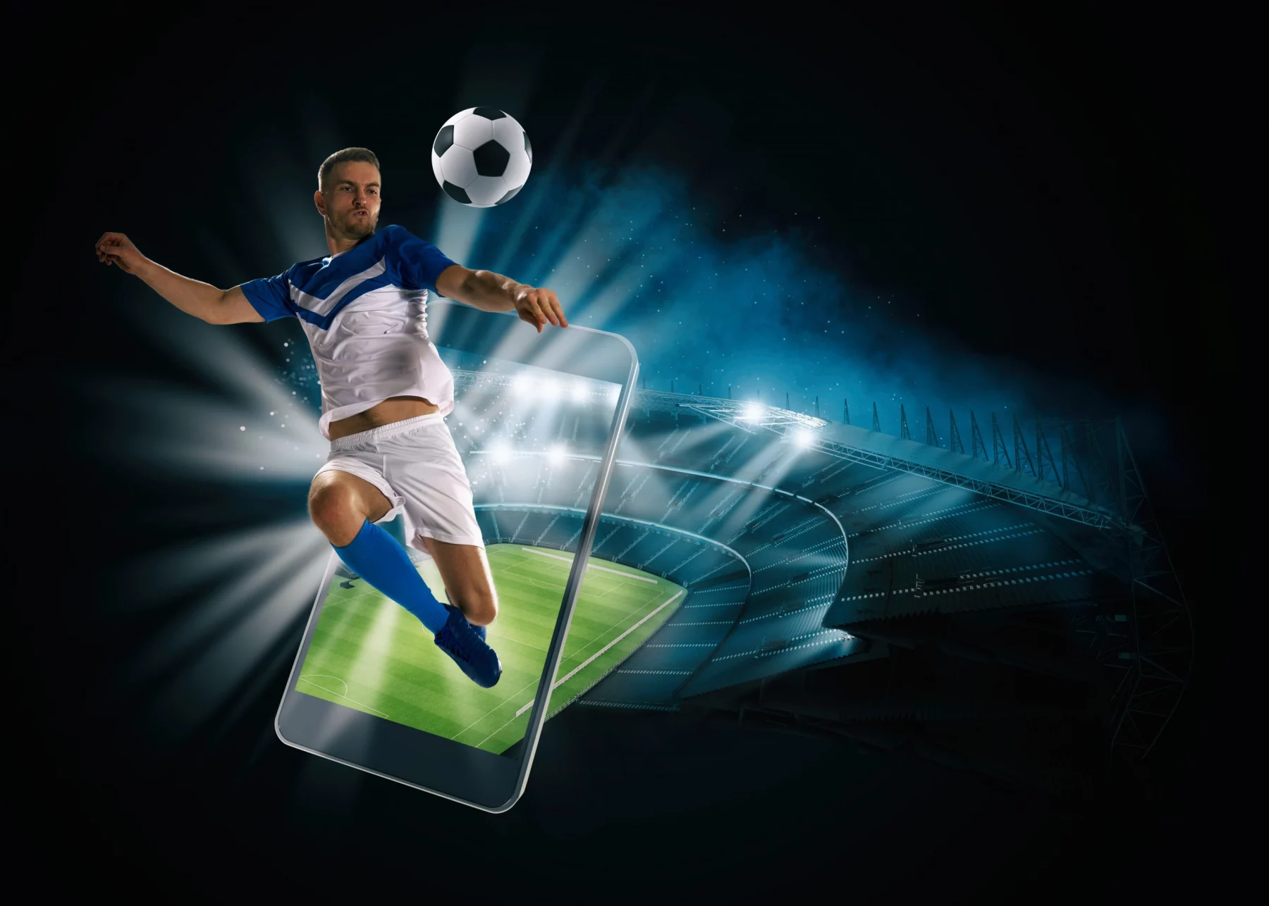 Soccer player, cellphone and ball on a stadium
