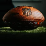 FootballR - NFL - Ein NFL-Football steht während Woche 4 auf einer Grasfläche.