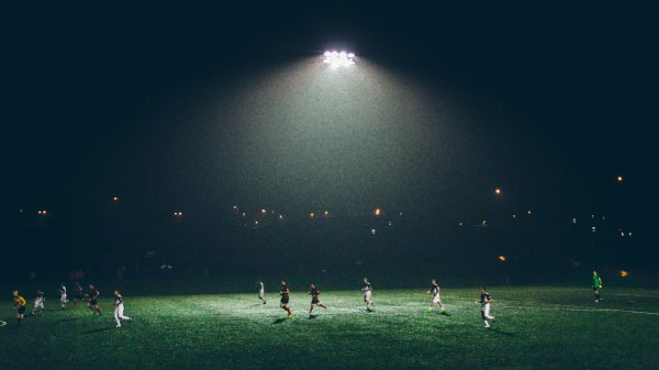 FootballR - NFL - Die großen Anwärter der Meisterschaft kämpfen unter den strahlenden Lichtern eines Fußballplatzes.