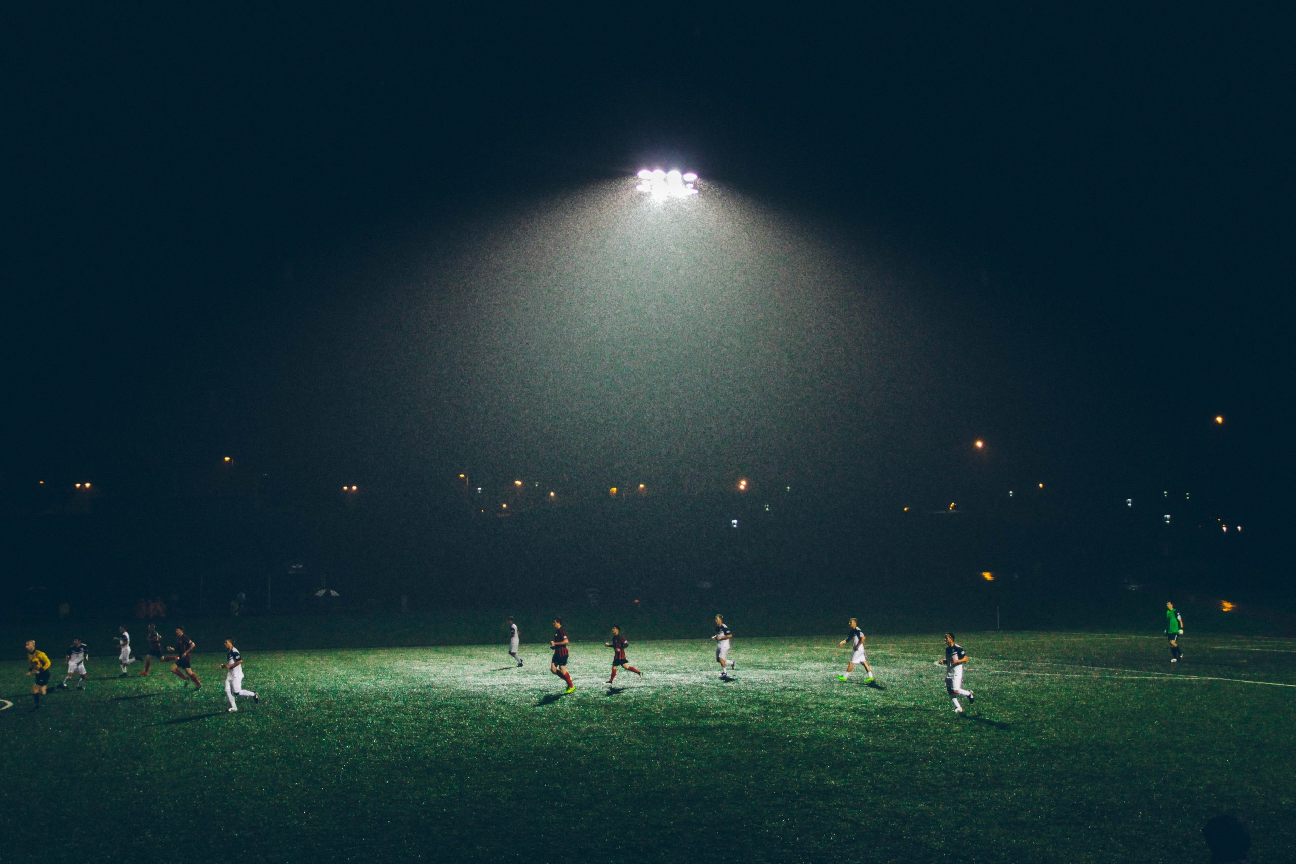 FootballR - NFL - Die großen Anwärter der Meisterschaft kämpfen unter den strahlenden Lichtern eines Fußballplatzes.