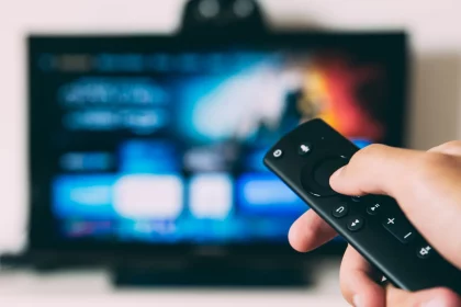 FootballR - NFL - Eine Person hält eine Fernbedienung vor einem Fernseher und zeigt die Dynamik des deutschen Sport-Streaming-Marktes.