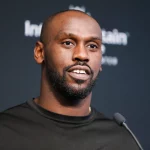 FootballR - NFL - Chandler Jones - Ein Mann in einem schwarzen Hemd steht bei der Pressekonferenz der Las Vegas Raiders vor einem Mikrofon.